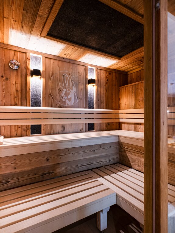 Holzsauna mit Bänken, Wandrelief und Glasfront