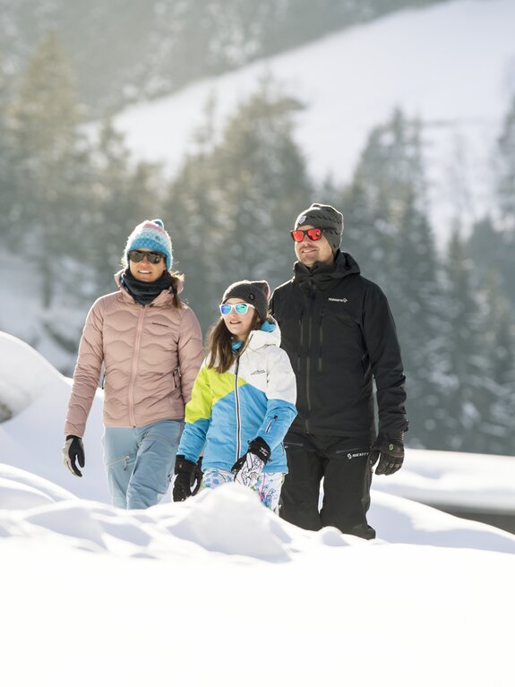 Familie wandert im Winter durch tiefen Schnee im Stubaital